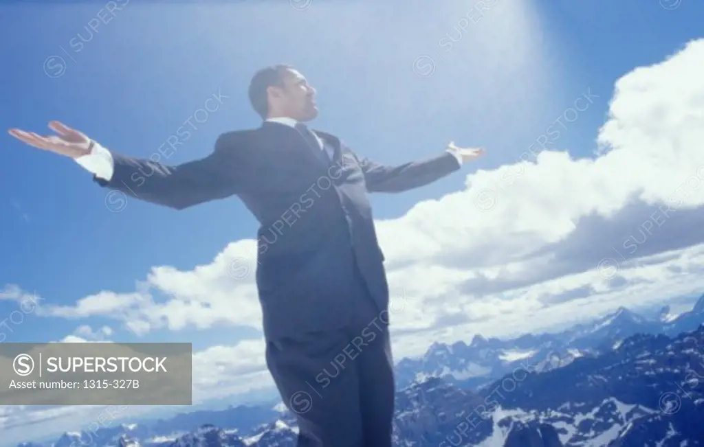 Low angle view of a businessman standing with his arm outstretched, Banff, Alberta, Canada