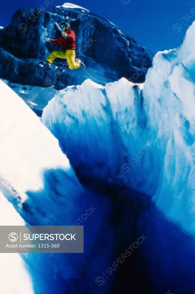 Man jumping across a crevice, Columbia Icefield, Jasper National Park, Alberta, Canada