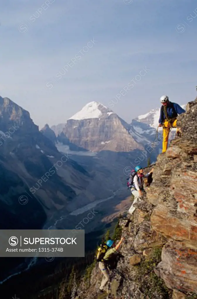 Two young women and a young man climbing a mountain, Lake Louise, Alberta, Canada