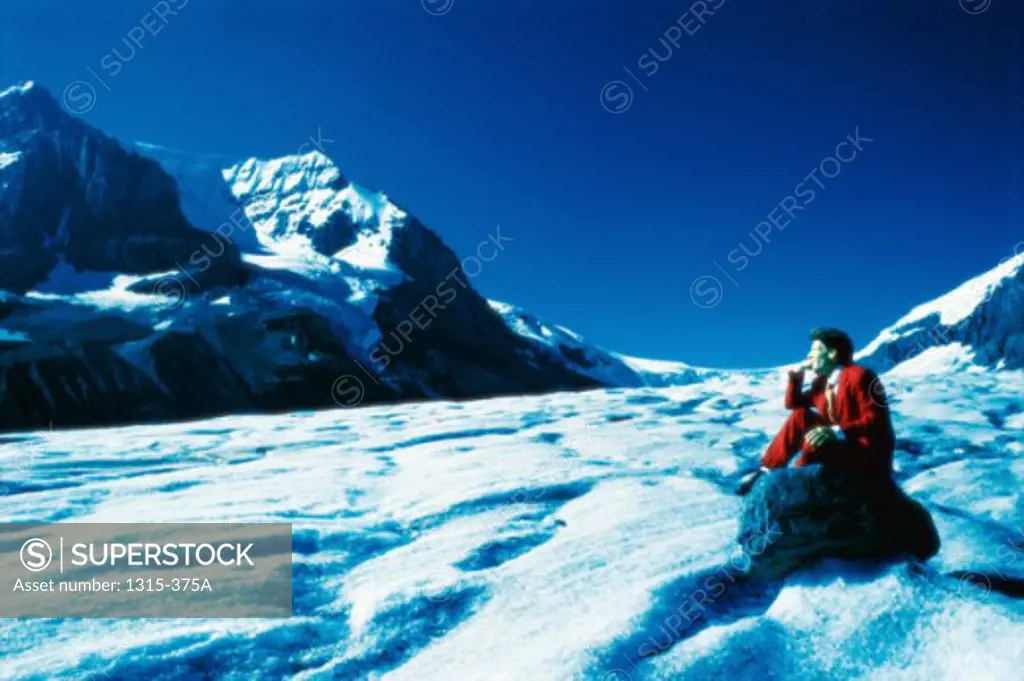 Side profile of a businessman sitting on a rock, Columbia Icefield, Jasper National Park, Alberta, Canada