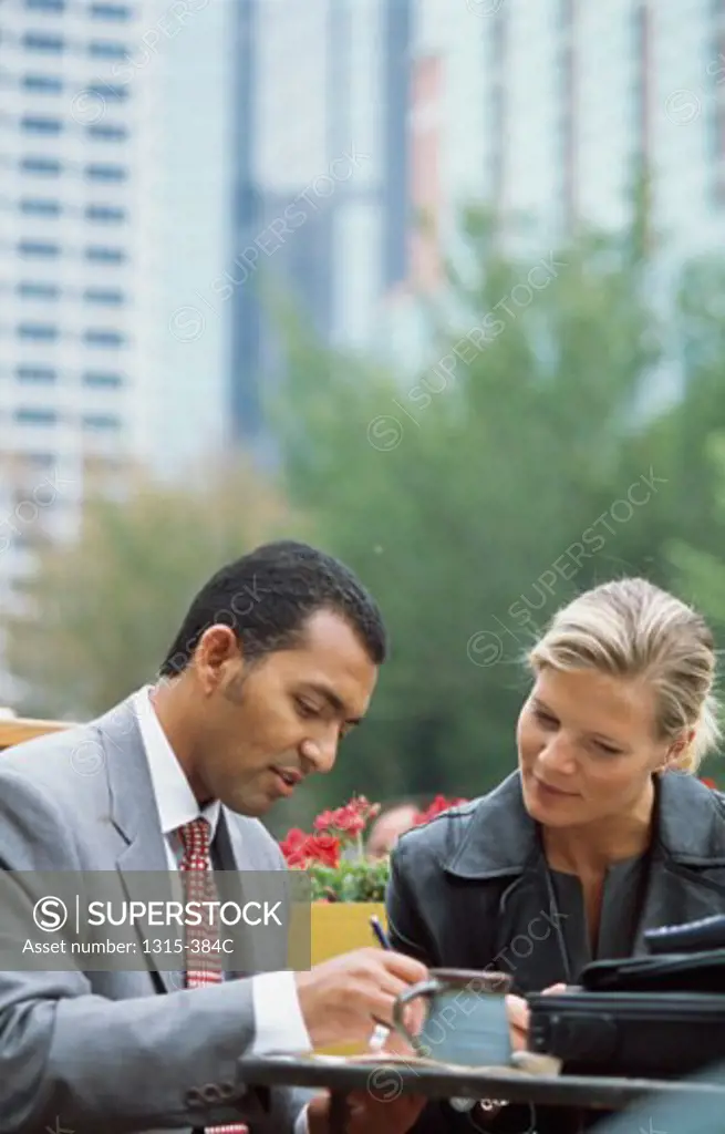 Businessman and a businesswoman sitting at a table