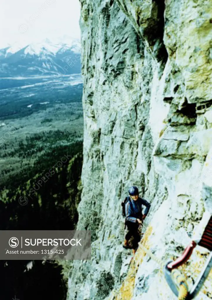 Young woman climbing a cliff, Canadian Rockies, Canada