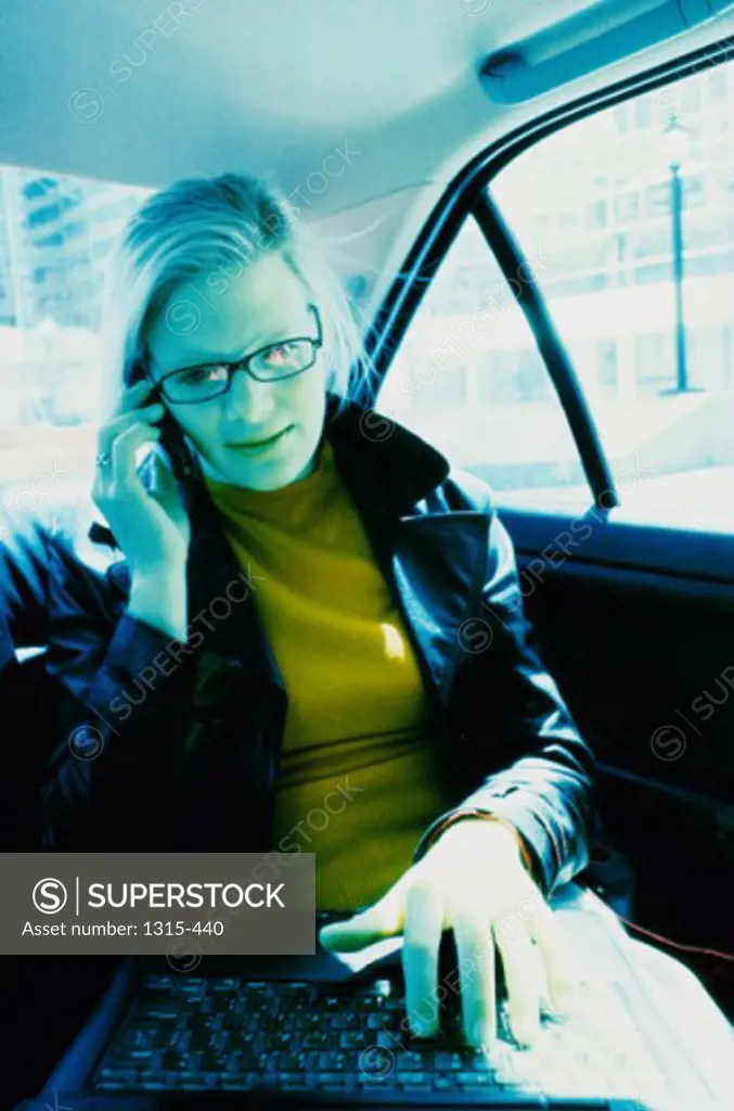 Businesswoman talking on a mobile phone in a car