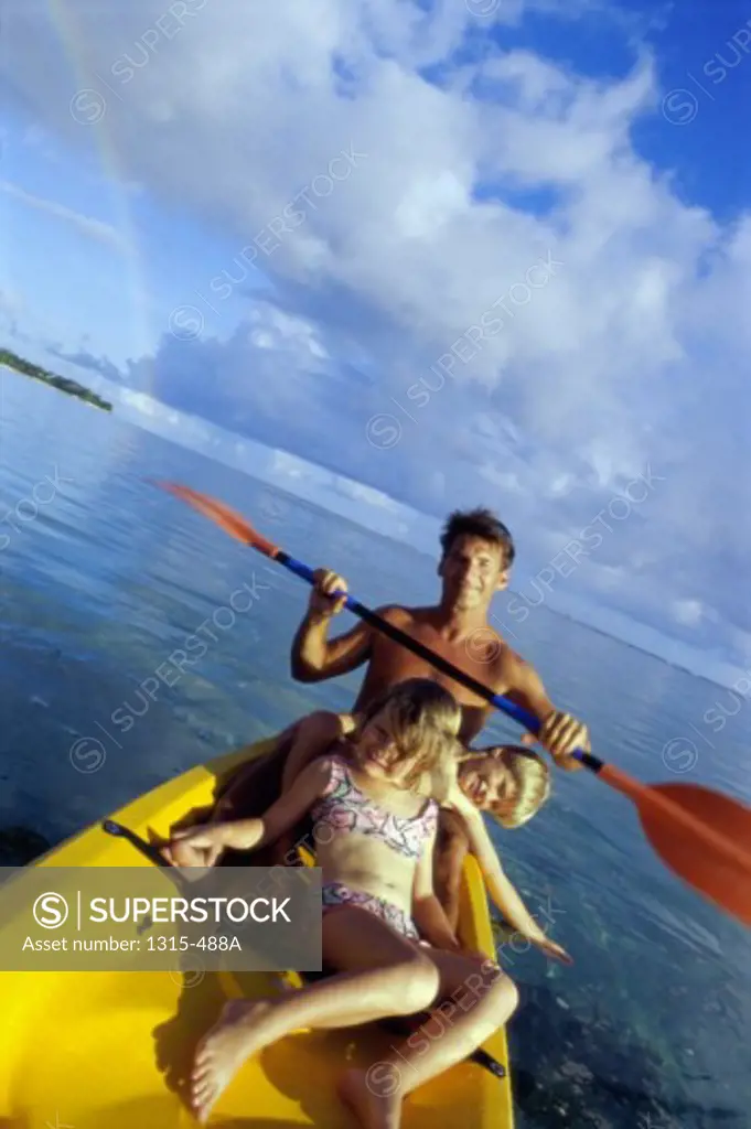 High angle view of a father with his son and daughter canoeing in the sea