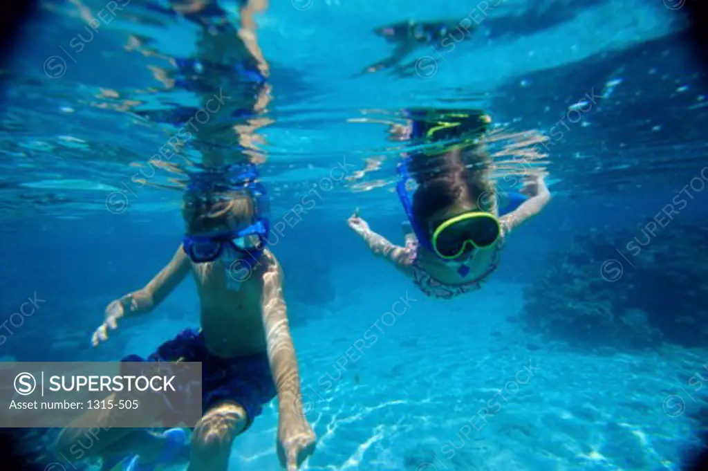 Brother and sister snorkeling in the sea