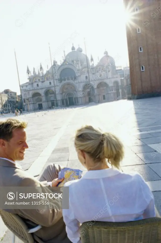 High angle view of a young couple sitting in front of a basilica, Basilica di San Marco, Venice, Italy