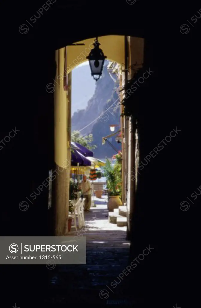 Man standing under a patio umbrella, Vernazza, Italy
