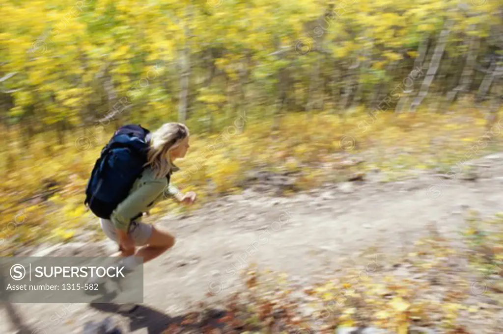 High angle view of a young woman running on a trail
