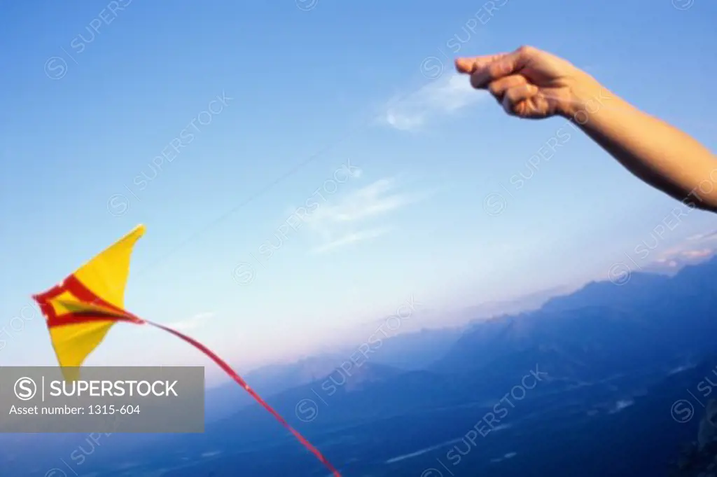 Person's hand flying a kite, Banff National Park, Alberta, Canada