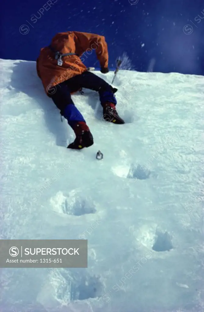 Low angle view of a man climbing a snow covered slope