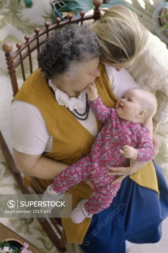 High angle view of a grandmother holding her grandson with her daughter sitting beside her
