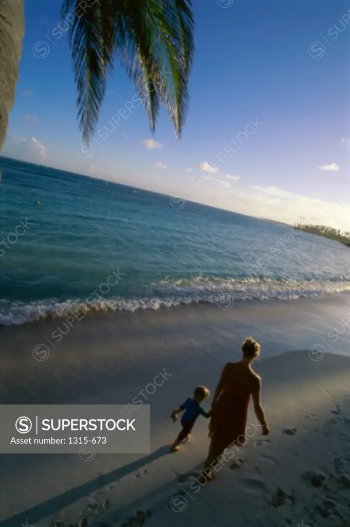 High angle view of a mother and son walking on the beach