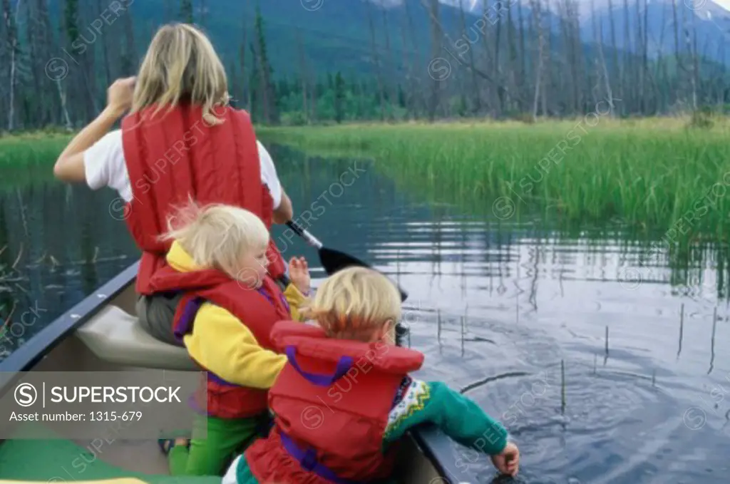 Mother rowing a boat with her children, Banff National Park, Alberta, Canada