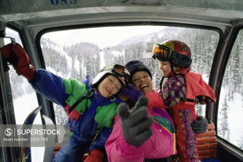 Portrait of a mother with her son and daughter in a cable car, Alberta, Canada