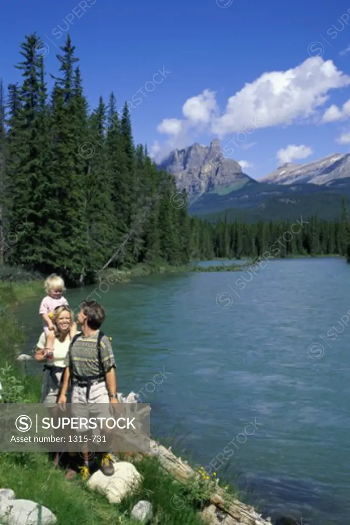 Parents with their daughter walking on the lakeside, Banff National Park, Alberta, Canada
