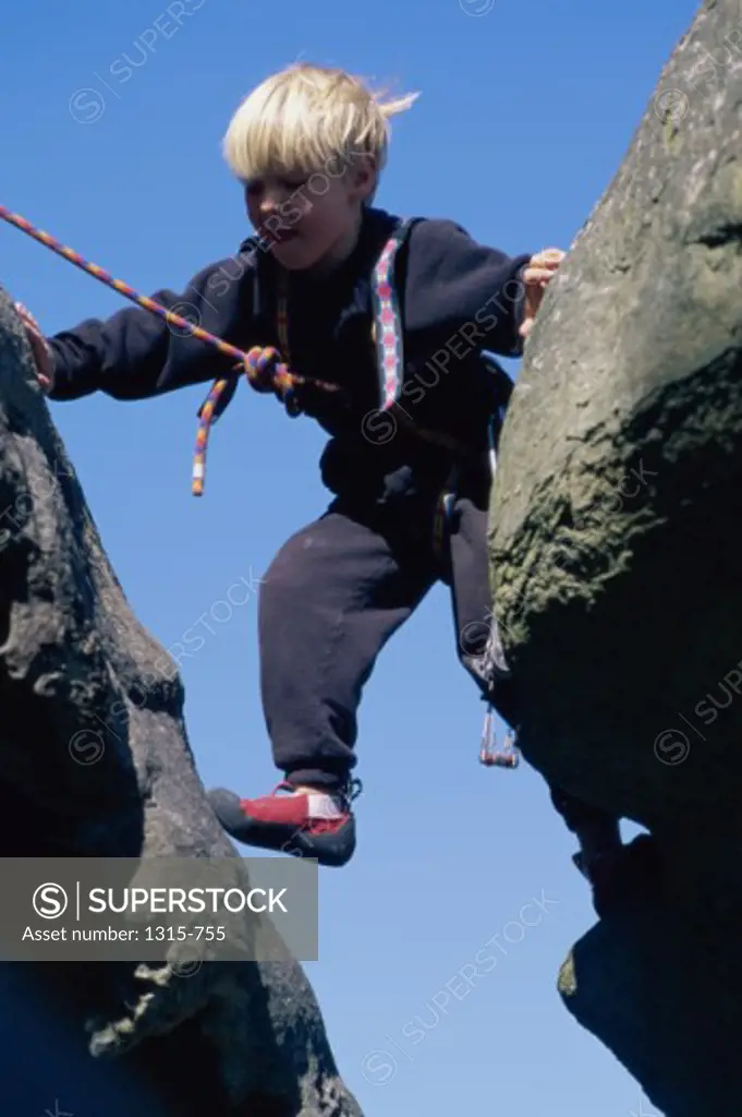 Low angle view of a boy climbing rocks