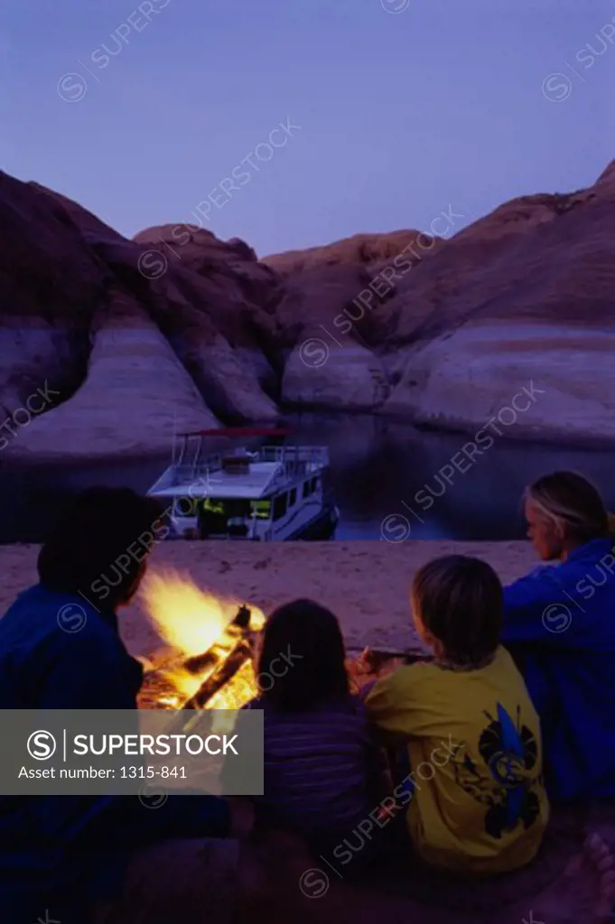 Rear view of parents with their son and a daughter at a campfire, Lake Powell, Glen Canyon National Recreation Area, Arizona-Utah Border, USA