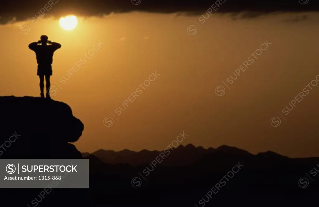 Silhouette of a man standing on a rock