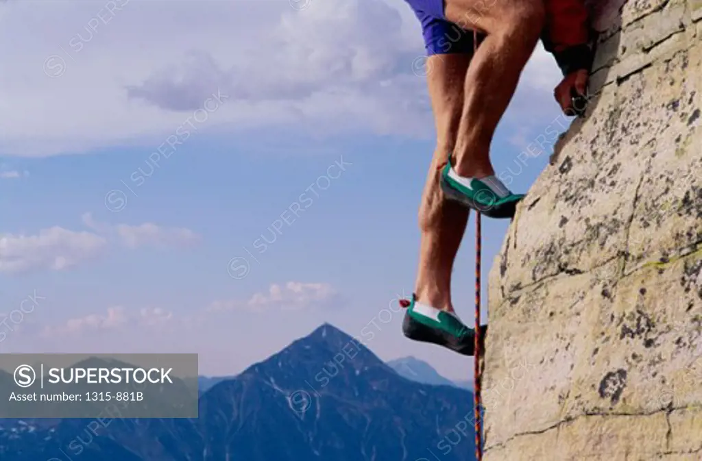 Low section view of a man climbing on a mountain
