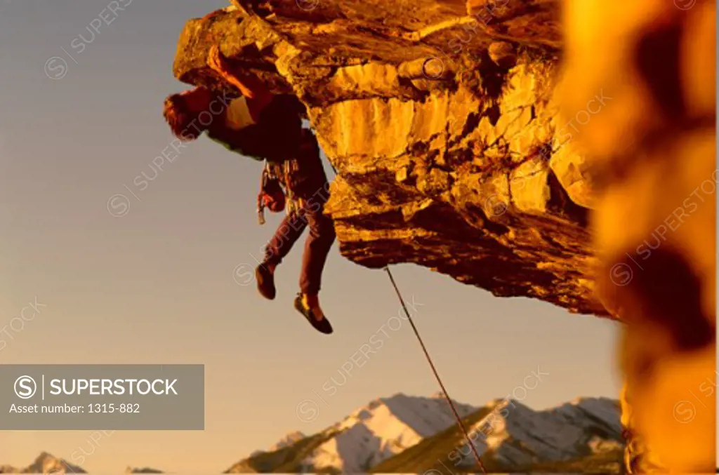 Mountain climber hanging from a rock