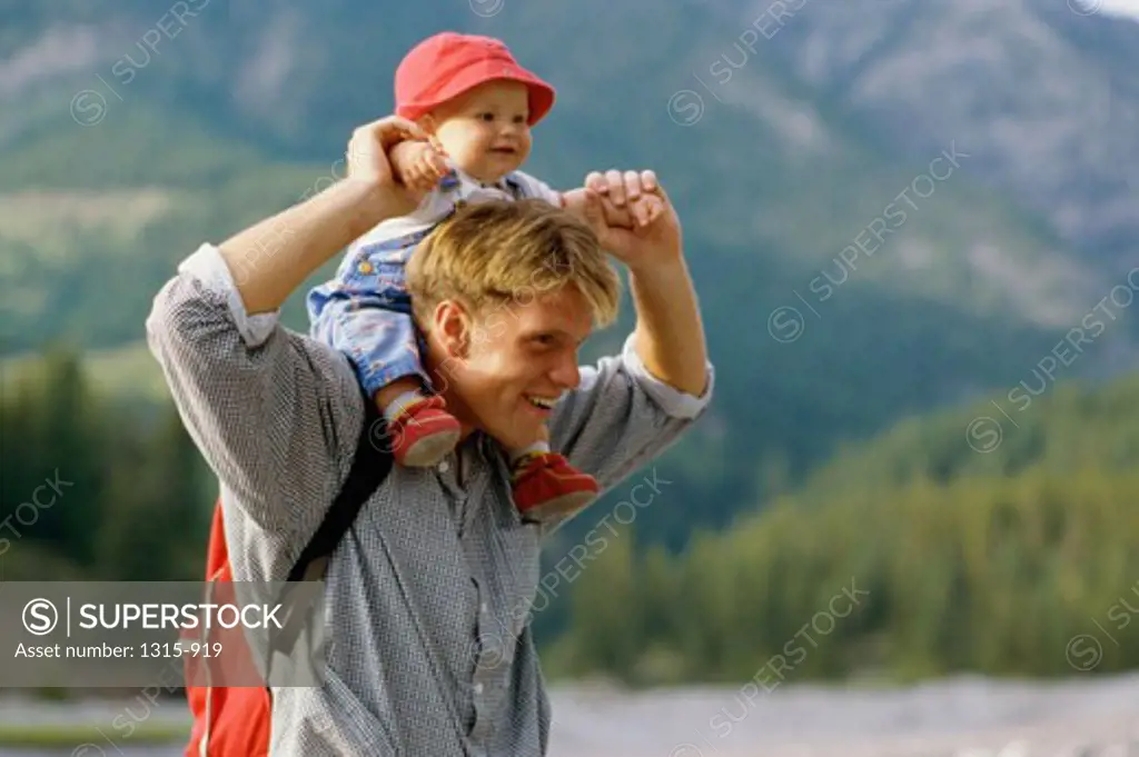 Side profile of a father carrying his daughter on his shoulders