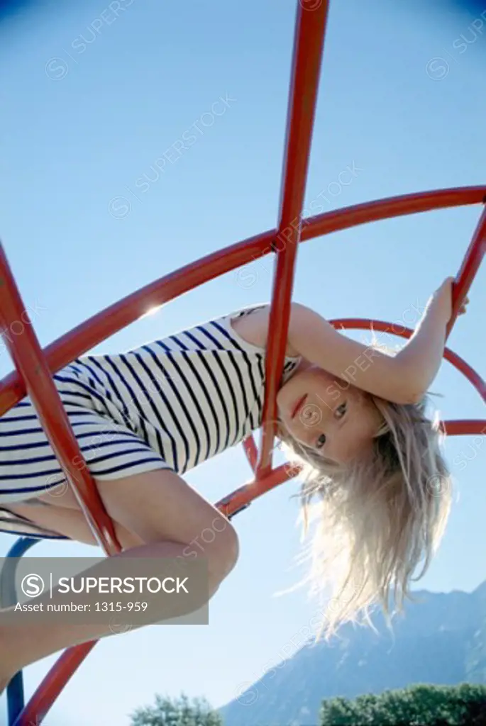 Low angle view of a girl playing on a jungle gym