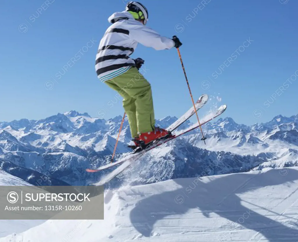 Italy, Piedmont, Jafferau, Teenage skier jumps over snowy ridgecrest