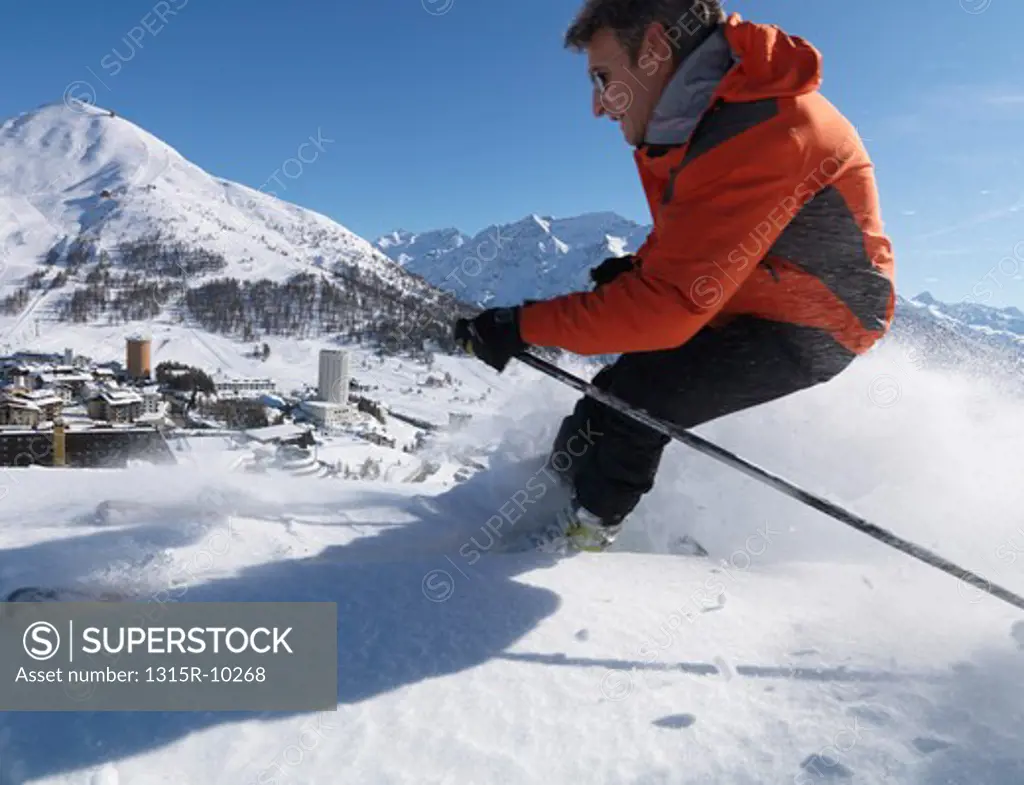 Italy, Piedmont, Sestriere village and ski resort (site of 2006 winter Olympics), with skier in foreground