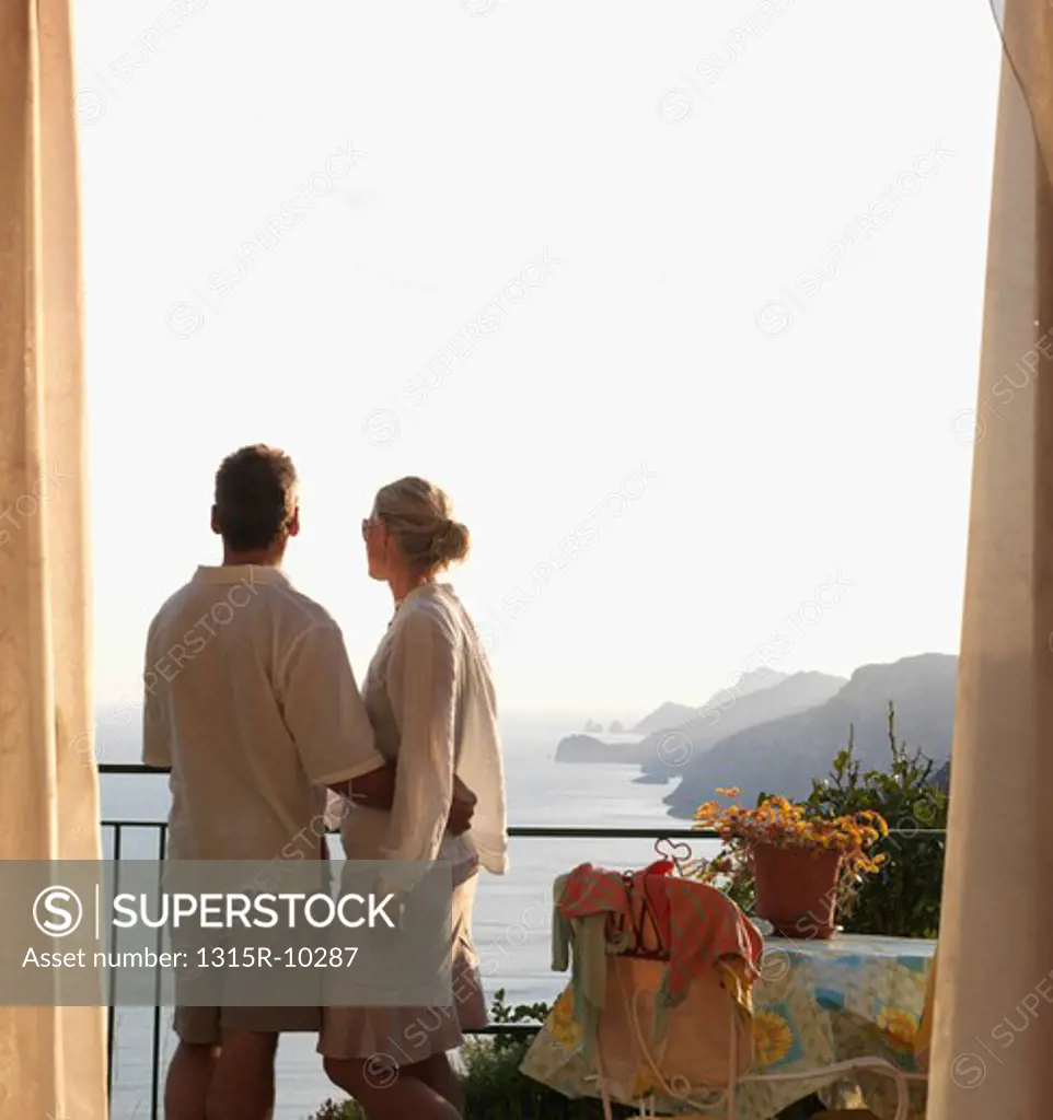 Italy, Amalfi, Couple look out from hotel suite over positano