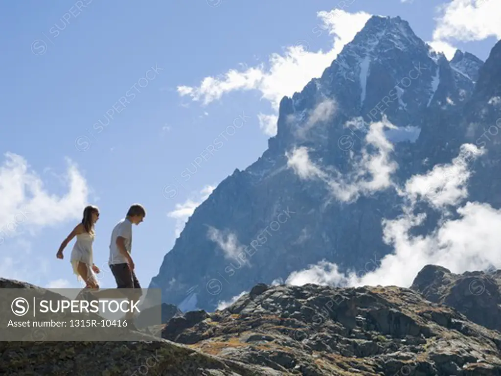 Italy, Piedmont, Teenage kids walking along mountain ridge