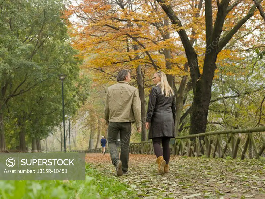 Italy, Piedmont, Turin, Couple walking along autumn path in city