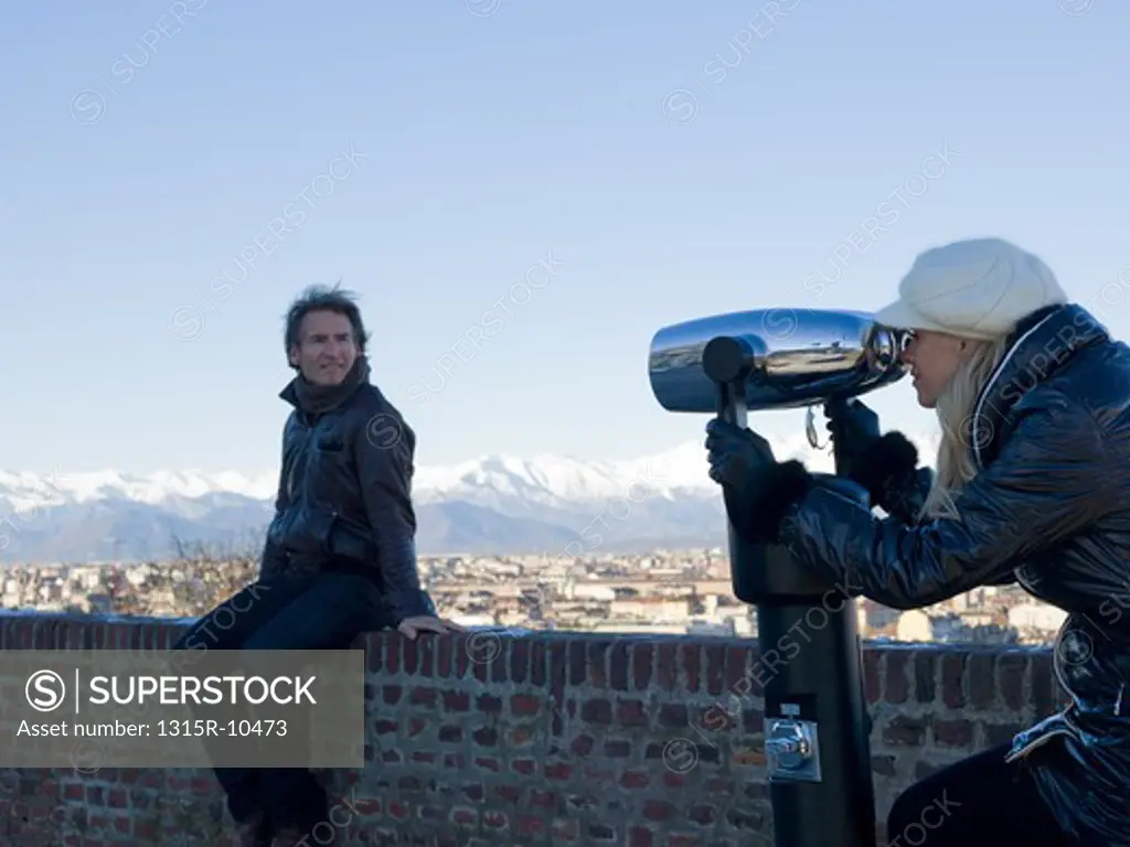 Italy, Piedmont, Turin, Couple looking through spotting telescope