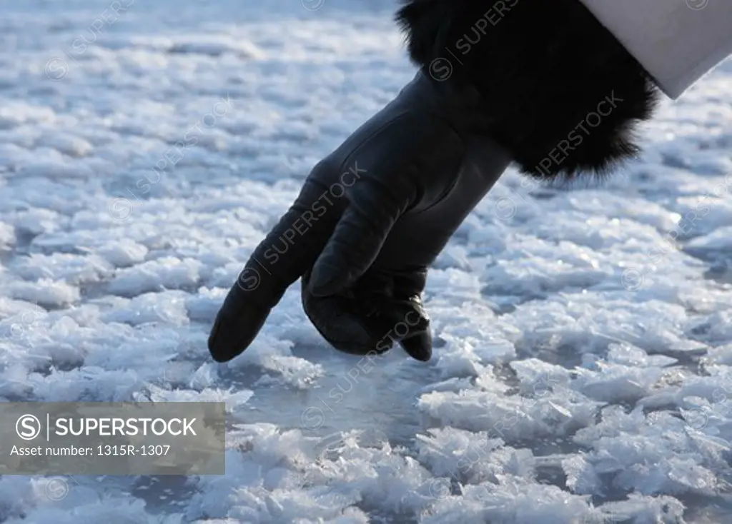 Canada, Alberta, close up of woman's gloved finger touching ice crystals
