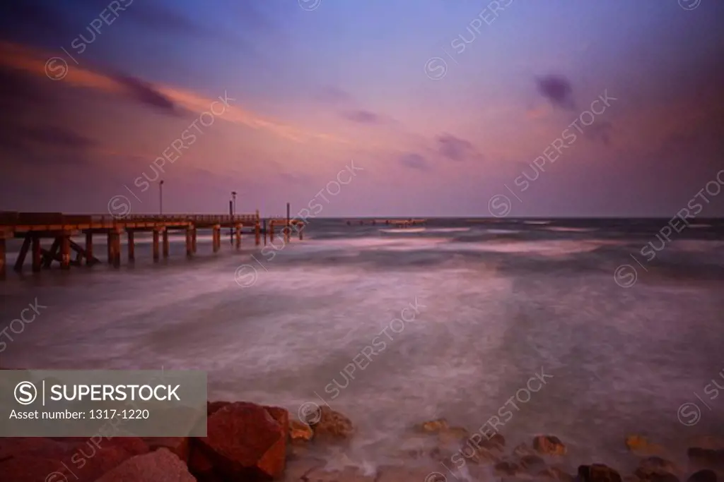 USA, Texas, Galveston, Early morning light with storm clouds at Fishing pier on Seawall Boulevard