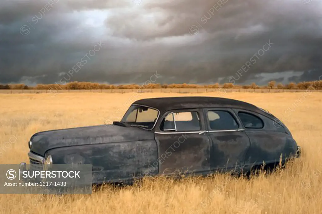 Old car rusting away in a field