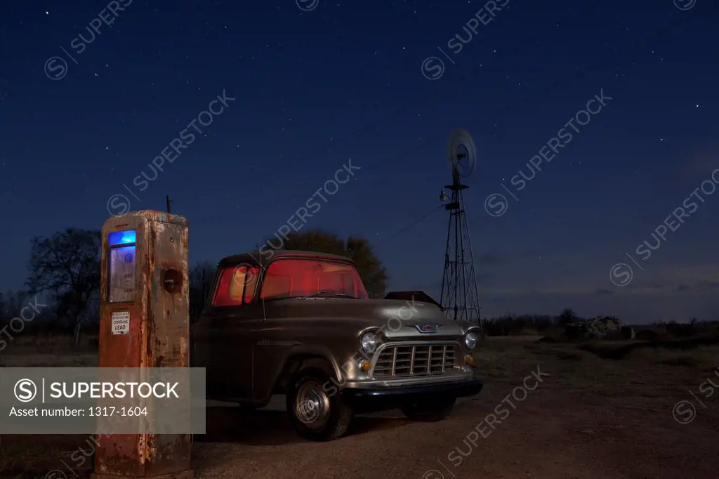 USA, Texas, Abandoned gas station pumps and truck at night