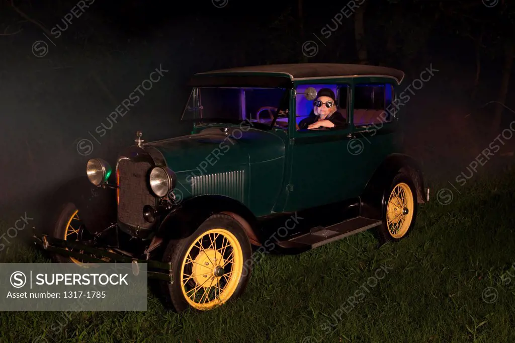 Woman inside a Vintage Model T car parked in a field