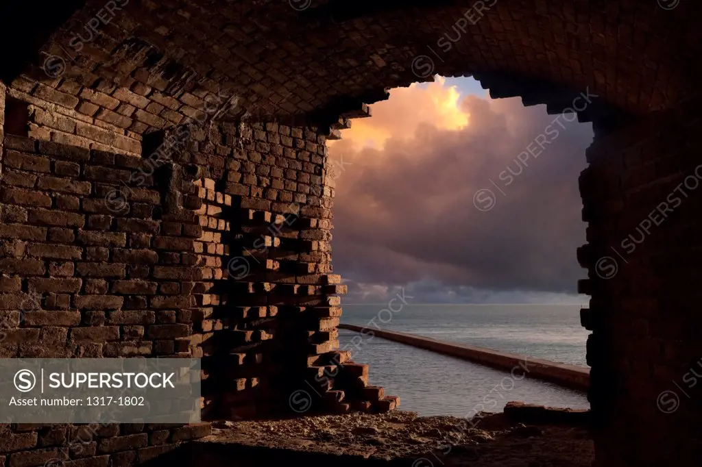 USA, Florida, Florida Keys, Dry Tortugas National Park, Looking out broken wall at Fort Jefferson during sunset