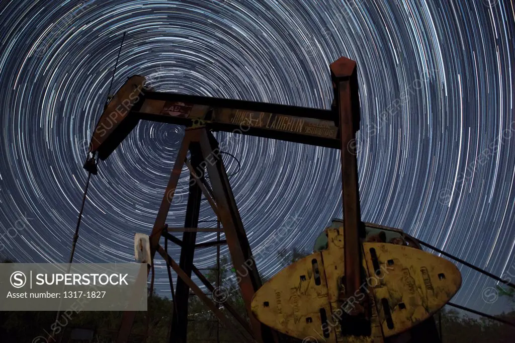USA, West Texas, Oil pump jack with star trails at night