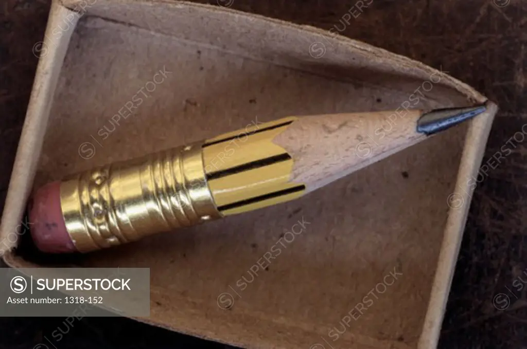 Close-up of a pencil sharpened to the very end in a cardboard box