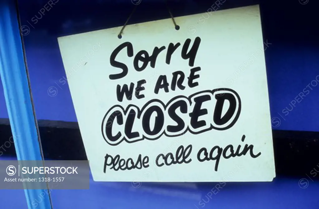 Detail of a shop door with sign stating Sorry We Are Closed Please Call Again, Suffolk, England