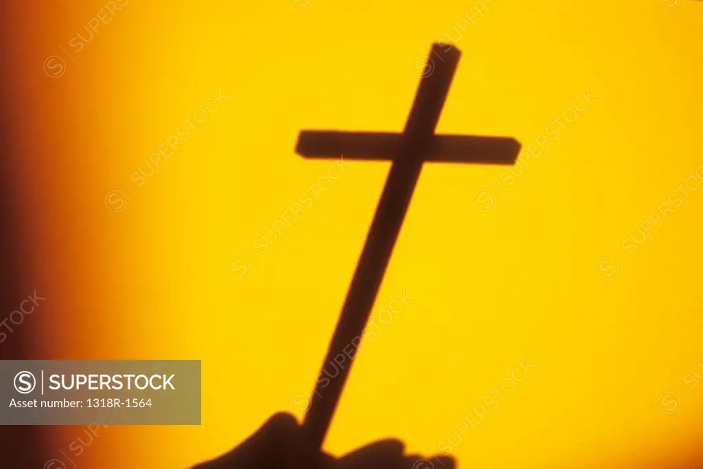 Shadow in warm sunset light of Crucifix in hand, Norfolk, England