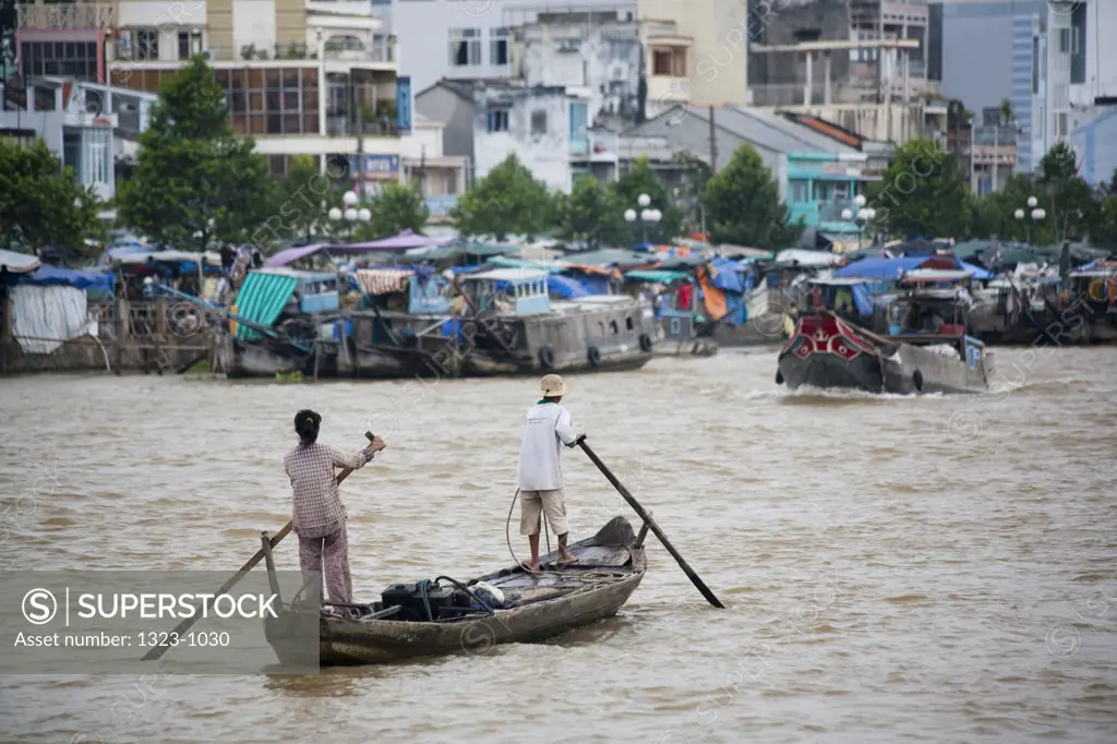 Men rowing a boat in a river, Mekong Delta, Mekong River, Vietnam