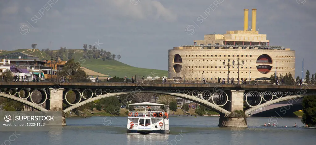 Tourboat passing under a bridge over a river, Triana Bridge, Guadalquivir River, Seville, Andalusia, Spain