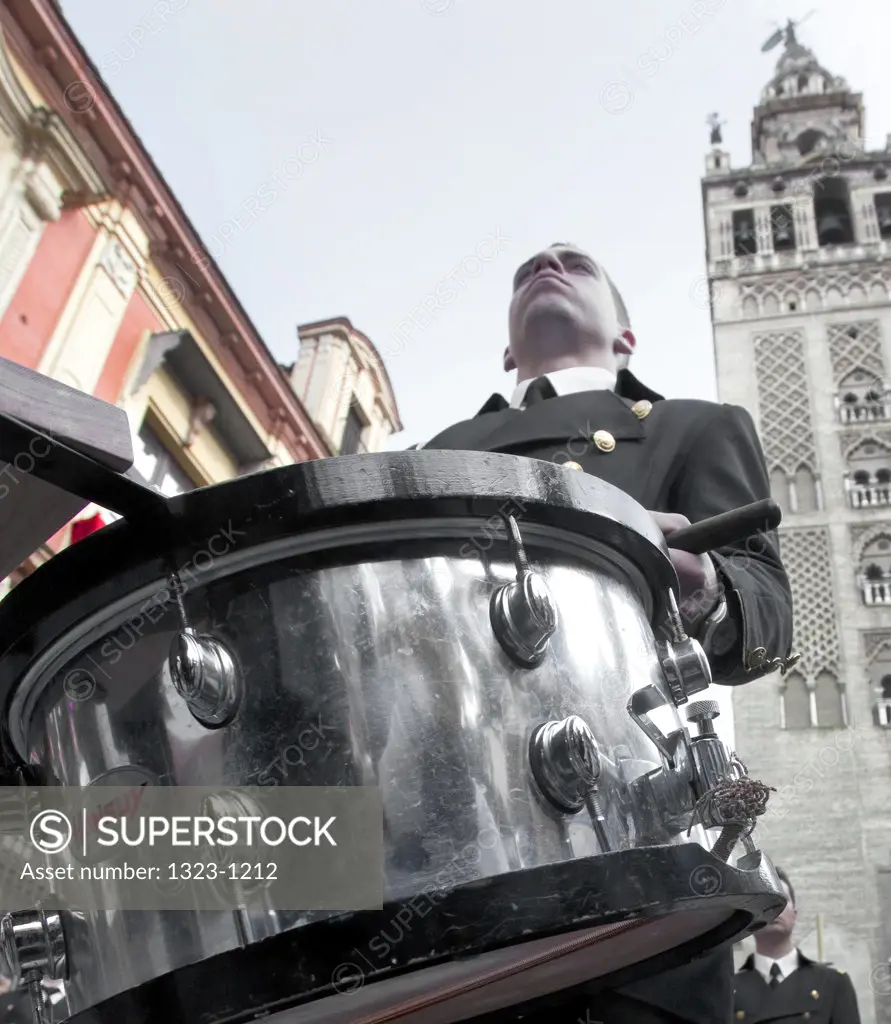 Spain, Seville, Low angle view of drummer in marching band during Easter festival
