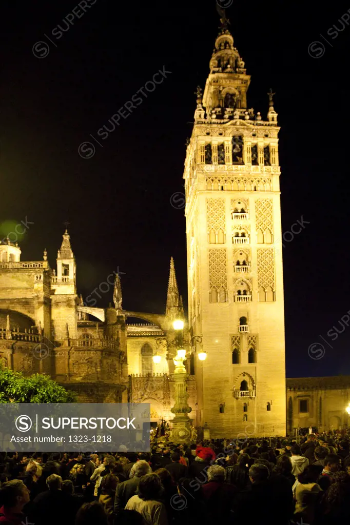 Spain, Seville, Low angle view of Seville Cathedral at night with crowd gathered for Holy Week celebrations