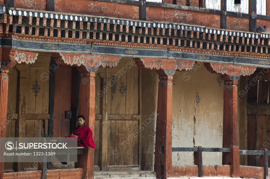 Monk resting on the railing of a monastery, Wangdue Phodrang Dzong, Wangdue Phodrang, Bhutan