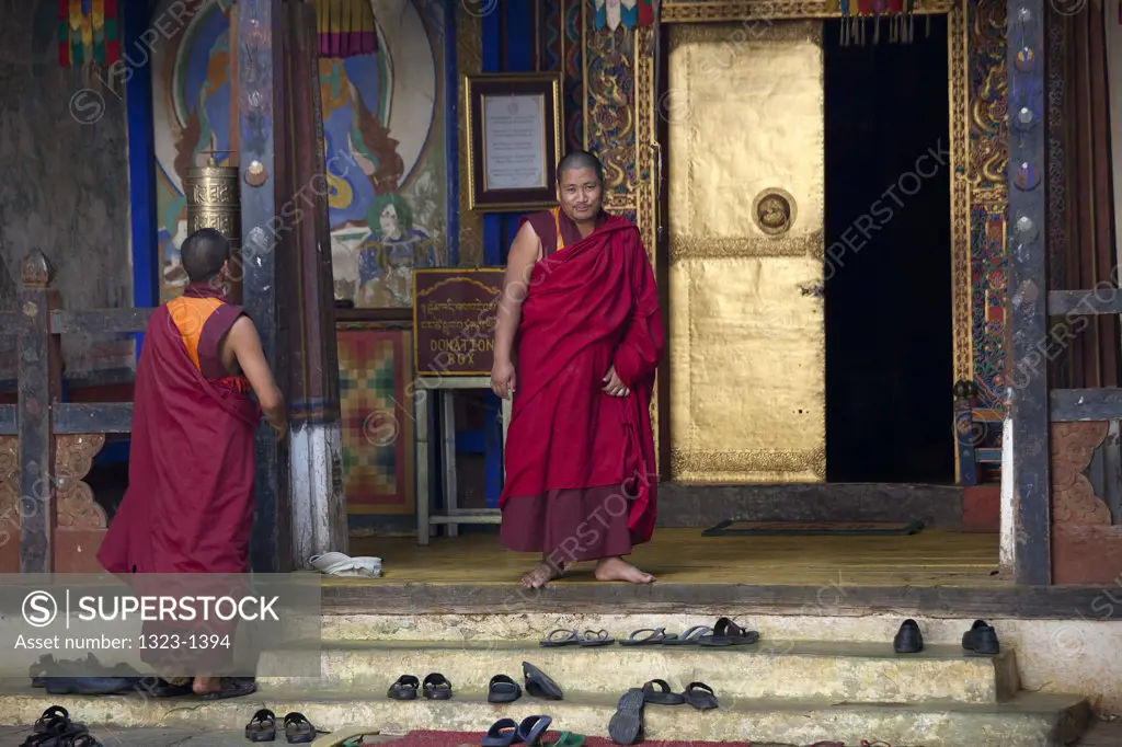 Monks standing in front of the entrance to a monastery, Bhutan