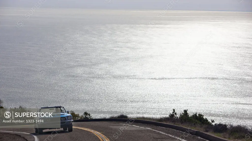 USA, California, Malibu, Car driving above coastline