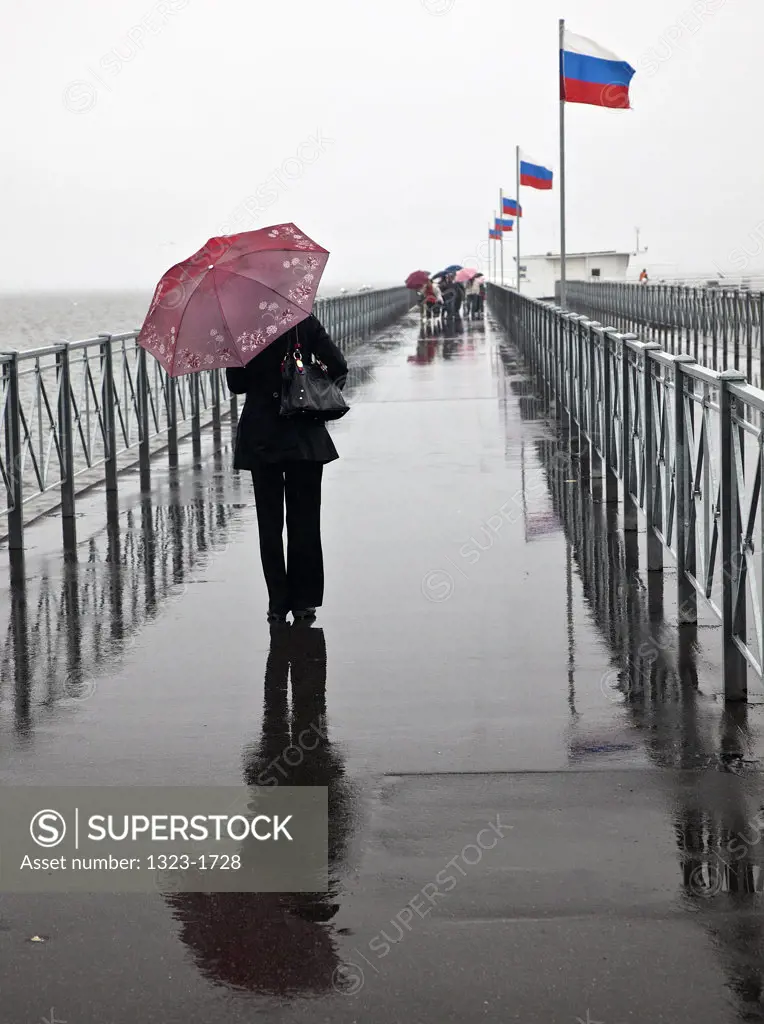 Women with an umbrella on the pier at Petrodvorets, St. Petersburg, Russia